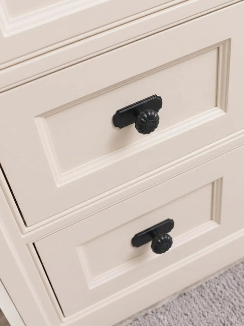 Matte Black Cabinet Knobs With Scalloped Backplates 6 Pack Featuring Slick Fluted Floral Handles And A Beaded Center Medallion on cream cabinet drawers.