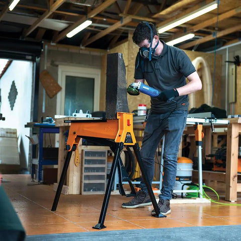 Man using Beefed Up Heavy Duty Portable Clamping Jawhorse With Foot Pedal For Hands Free Operation Folding Workbench Tripod Table 2200lb Capacity Ideal For Woodworking Repairs And Construction in workshop