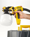FlexiO 890 HVLP Paint Sprayer Shoots Unthinned Latex Smooth As Butter With Dual Nozzles, handheld view with cup.