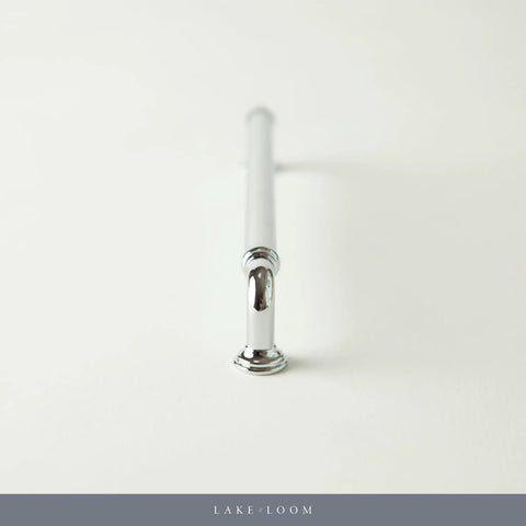 Chrome cabinet pull handle on white background, view from end.