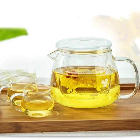 Sleek Heat Resistant Glass Teapot For Cold Brew And Hot Tea, Smooth Drip Pour Spout Juice Pitcher, Solid Borosilicate Server With Comfy Grip Handle, Lead Free Kitchen Essential For Daily Grind with brewed tea and cups.