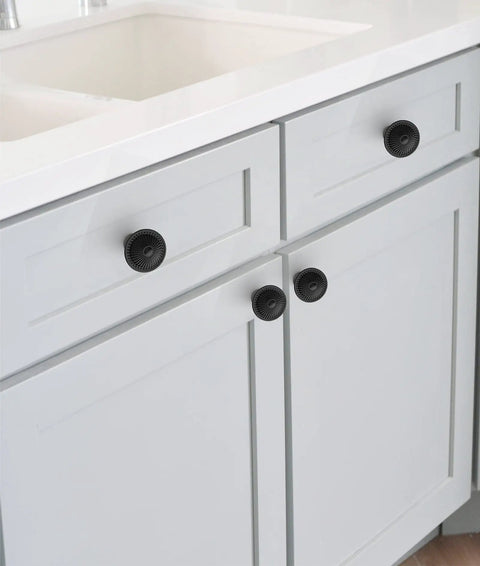 Flat Black Cabinet Knobs Set 30 Pack on white kitchen cabinets, round pulls with sunburst pattern, vintage dresser chest door hardware.