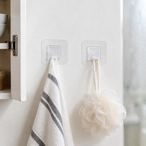 Sick Wall Mount Hooks, Totally Rust Proof Storage Rack For Coats, Bags, And Picture Hanging, white towel and loofah hanging on clear hooks.