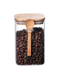 Hella Airtight Hand Blown Glass Coffee Canister With Spoon For Top Shelf Kitchen Organization with coffee beans inside.