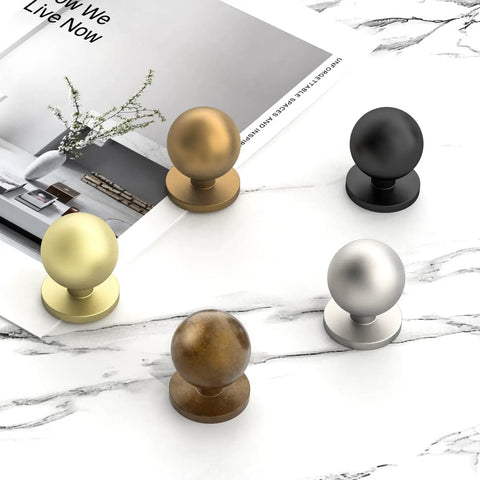 30 Pack 1 Inch Round Solid Ball Cabinet Knobs In Rich Champagne Bronze Finish Designed For Kitchen And Bathroom Drawer Pulls Delivering A Tight Fit And Dead Simple Setup With Zero Sweat Required with assorted finishes on marble background.