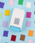 Lever Action Postage Stamp Punch 1x0.8 Inch Rectangular Stamp Shaped Paper Punch For Scrapbooking Card Making Journaling And Crafting Durable Craft Cutter For DIY Projects And Handmade Cards on blue background with colorful punched paper shapes.
