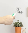 Close-up of All Purpose Wall Putty Repair Kit With Nozzle For Drywall Spackle Paste being applied to a wall hole next to a potted plant.