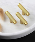 Brass cabinet pulls with knurled texture on marble tray