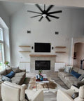 Living room featuring sofas, a coffee table on a rug, and a large TV above a fireplace in a relaxed interior design.