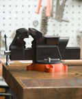 Bench vise by VEVOR, 6-inch jaw, with 360° swivel base and anvil, mounted on an orange base.