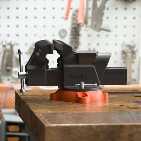 Bench vise by VEVOR, 6-inch jaw, with 360° swivel base and anvil, mounted on an orange base.