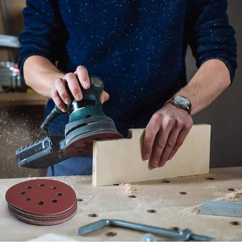 Person sanding wood with orbital sander and 70 Pack 5 Inch 8 Hole Sanding Discs 800 1000 1200 1500 2000 2500 3000 Grit Aluminum Oxide Sandpaper Set.