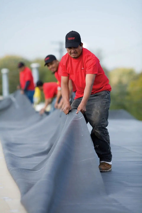 Heavy Duty 45 Mil Epdm Roofing Membrane 10 Feet By 200 Feet Roll For Flat Roofs And Low Slopes utilized by workers on a roof.