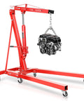 Two Ton Hydraulic Engine Hoist Crafted As A Garage Workhorse For Straight Up Heavy Transmissions And Motors Includes Foldable Cherry Picker Arm With Six Swivel Casters lifting an engine with a sturdy red frame.