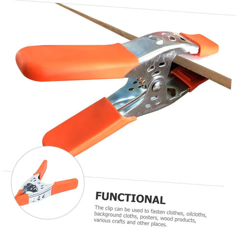 Heavy Duty Metal Spring Clamps With Ergonomic Handles Built Tough For Woodworking Carpentry And Model Making Red Coated Shop Essentials. Close-up of orange handled clamp holding a wooden strip.