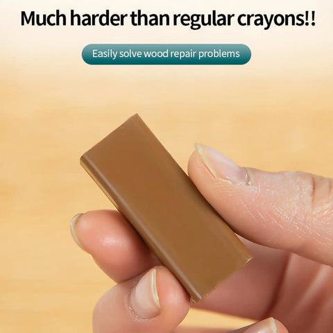 Close-up of hand holding Wax Repair Stick For Quick Fix On Wood Floors And Furniture Scratches, heat activation shown