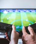Two people playing video games on a television using controllers, showcasing Hide Messy TV Cables Behind The Wall With This In Wall Cable Management Kit 4 Pass Throughs 1 Hole Saw Drill Attachment Two And Three Eighths Inch Hole Easy To Install For Wall Mounted Televisions Durable In Wall Wire Hider for clean setup.