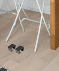 4 Pack Black Plastic Outdoor Furniture Clips for Sofas and Beds with firm grip on wooden floor by white metal chair legs