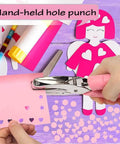 Person using Heart Shaped Paper Punch Handheld Perforator for DIY crafts, creating heart-shaped holes in pink paper on a colorful craft table.