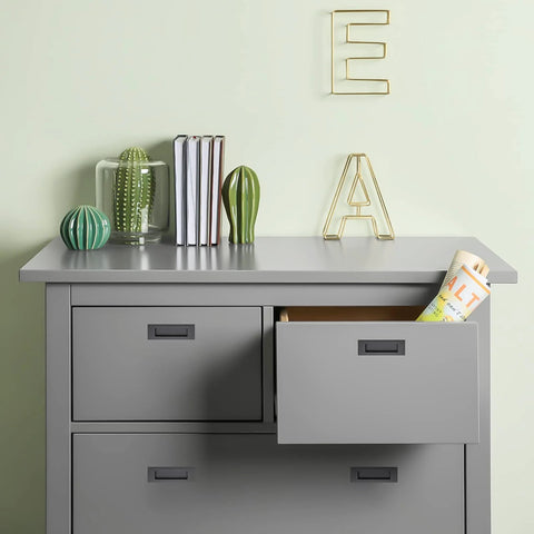 Gray dresser with open drawer, books, and decorative items