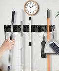 Heavy Duty Broom Holder Wall Mount Organizer 2 Pack With 5 Adjustable Slots And 6 Foldable Hooks in use holding cleaning tools