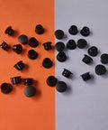 Thirty Pcs Black Plastic Hole Plugs For Cabinet And Screw Holes, 13 Mm Bottom Diameter, Caps On Orange and Gray Background