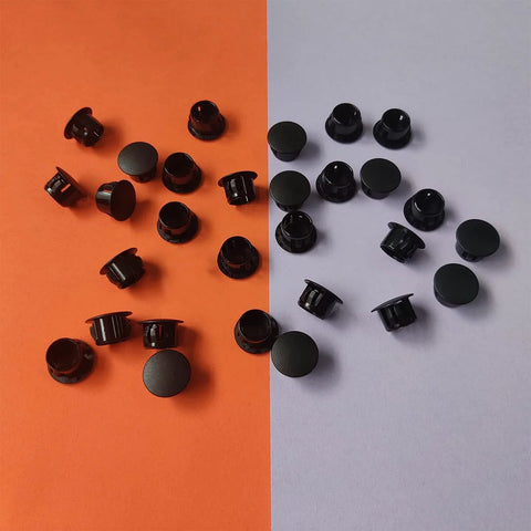 Thirty Pcs Black Plastic Hole Plugs For Cabinet And Screw Holes, 13 Mm Bottom Diameter, Caps On Orange and Gray Background