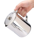 Hand holding a Stainless Steel Milk Frothing Pitcher With Lid And Dripless Spout 2000ml Pro Grade For Latte Art Ready Milk Steaming Durable