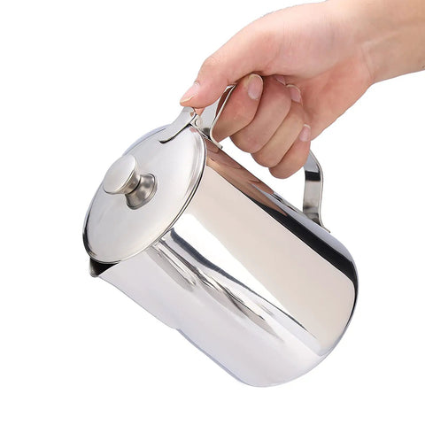 Hand holding a Stainless Steel Milk Frothing Pitcher With Lid And Dripless Spout 2000ml Pro Grade For Latte Art Ready Milk Steaming Durable