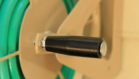 Close-up of the crank handle of the Built Tough Heavy Duty Steel Garden Hose Reel Wall And Floor Mount, tan finish.