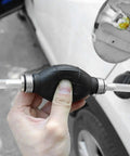 Top Shelf Manual Fuel Transfer Pump With Thick Rubber Bulb And Metal Body Shifts Gasoline Diesel And Oil One Way Vacuum Primer in hand.