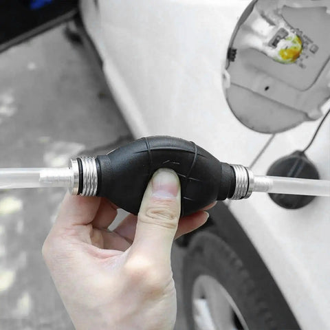 Top Shelf Manual Fuel Transfer Pump With Thick Rubber Bulb And Metal Body Shifts Gasoline Diesel And Oil One Way Vacuum Primer in hand.