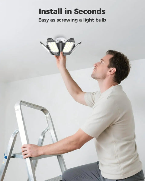 Man installing 2 Pack LED Garage Lights 20000LM 6500K Beast Bright Shop Lighting With 6 Adjustable Panels on ceiling