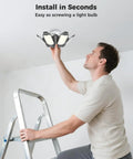 Man installing Ultra Bright 250W LED Garage Light 25000LM with 7 Foldable Panels on ceiling from ladder