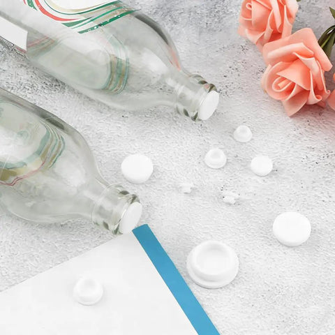 80 Piece Silicone Hole Plugs Kit With 8 Sizes Round Grommets on table near glass bottles and roses, white silicone plugs
