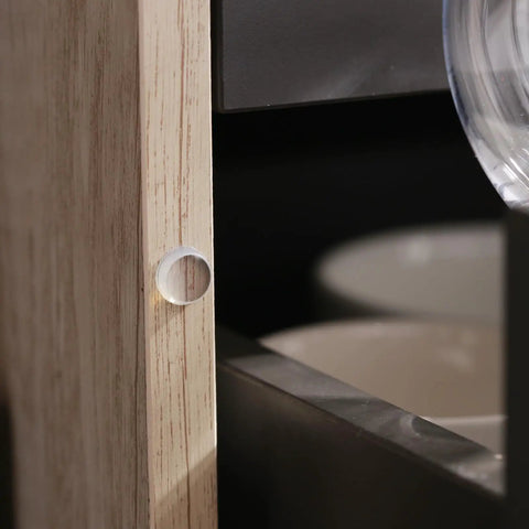 Clear Silicone Cabinet Door Bumper applied to wooden cabinet edge, part of 300 Pieces Clear Silicone Cabinet Door Bumpers With Super Tacky Self Adhesive Back Anti Slam Furniture Pads For Drawers And Furniture Easy Peasy Install Guaranteed Zero Slams Forever.