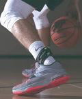 Performance POD Ankle Brace For Rock Solid Stability And Support In Football Soccer Basketball Lacrosse And Volleyball Protection On Demand Tech Activates When Needed To Stop Ankle Rolls Molded TPU Shell Adapts To Your Ankle For A Small Right Fit shown on athlete playing basketball.
