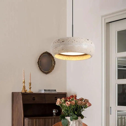 Modern Dome Yellow Travertine Pendant Light, Nordic Natural Stone Hanging Lamp over a wooden table with flowers.