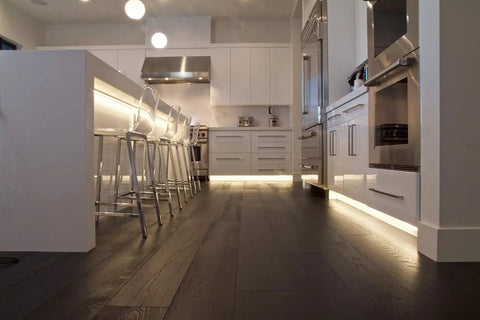 Modern kitchen with under-cabinet lighting using Basics 200 LED Tape Light 24V 3000K Warm White, 16.4ft Roll, enhancing ambiance.