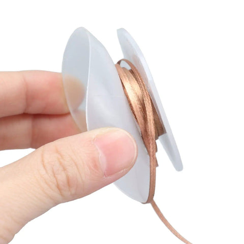 Hand holding Pro Grade Alloy Copper Desoldering Braid For Electronics Repair And PCB Work, 1.5 Meter Length, 1.5mm Width spool