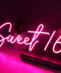 Pink Sweet 16 LED Neon Sign 17 By 7.3 Inches USB Powered Wall Decor for Bedroom Birthday Party glowing on table