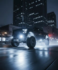 Truck with 12 Pod White Rock LED Underglow Lights Kit 6000K Pure White IP68 Waterproof speeding on wet city street at night.