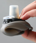 Close-up of a gray Hands Free Hydration Wrist Bottle for Runners, 200ml, silicone, leak-proof, ergonomic grip for workouts.
