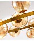 Close-up view of modern chandelier with glass balls and golden accents, ideal for dining room pendant lights.