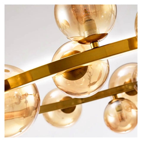 Close-up view of modern chandelier with glass balls and golden accents, ideal for dining room pendant lights.