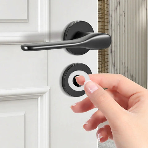 Hand placing Stainless Steel Spindle Washers for Door Knob Kits, 100 Pack Flat Thin Silver Metal Washers, Noise Reduction for Quiet, Smooth Operation, Easy Install, Durable Hardware Upgrade for Home Renovation and Residential Use on a black door lever