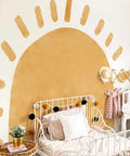 Large Fabric Watercolor Boho Half Sun Wall Decals Peel And Stick Pastel Sunrise Mural For Kids Baby Room Playroom Nursery Bedroom 94.49 Inches By 70.87 Inches Self Adhesive Arch Decor showing a pastel boho sun design above a bed in a nursery.