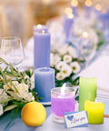 Table decorated with colorful candles and flowers, featuring the "All In One Candle Making Kit For Beginners With 2.12 Lb Soy Wax Dyes Wicks Stickers And More DIY Wax Melt Kit For Adults And Craft Lovers Super Easy To Use Budget Friendly Bang For Buck."