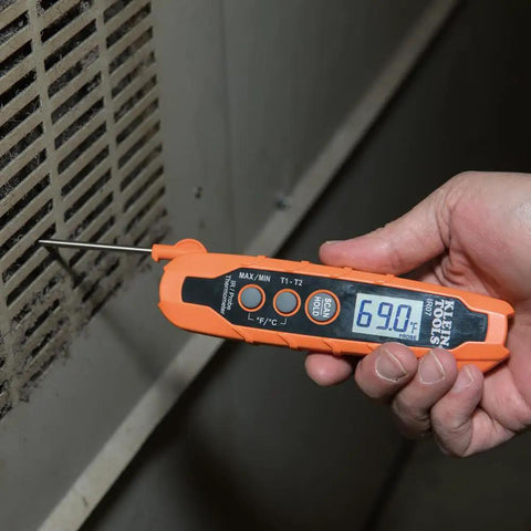 Person using IR07 Dual Infrared And Probe Pocket Size LCD Digital Thermometer near a vent, displaying 69.0F.
