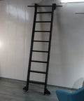 Heavy Duty Black Steel Sliding Ladder Track Rail System With Slick Floor Roller Wheels And No Sweat Retractable Pulleys For Loft Storage Pantry Carts Wine Cellars Built Tough mounted on a wall.